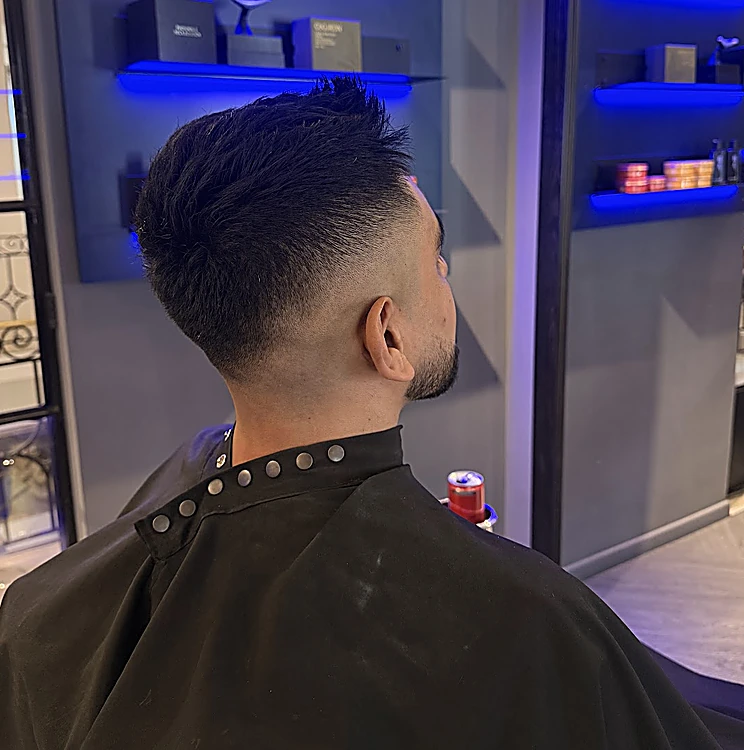 Fade alto con la nuca marcada y el pelo texturizado arriba, visto desde atrás